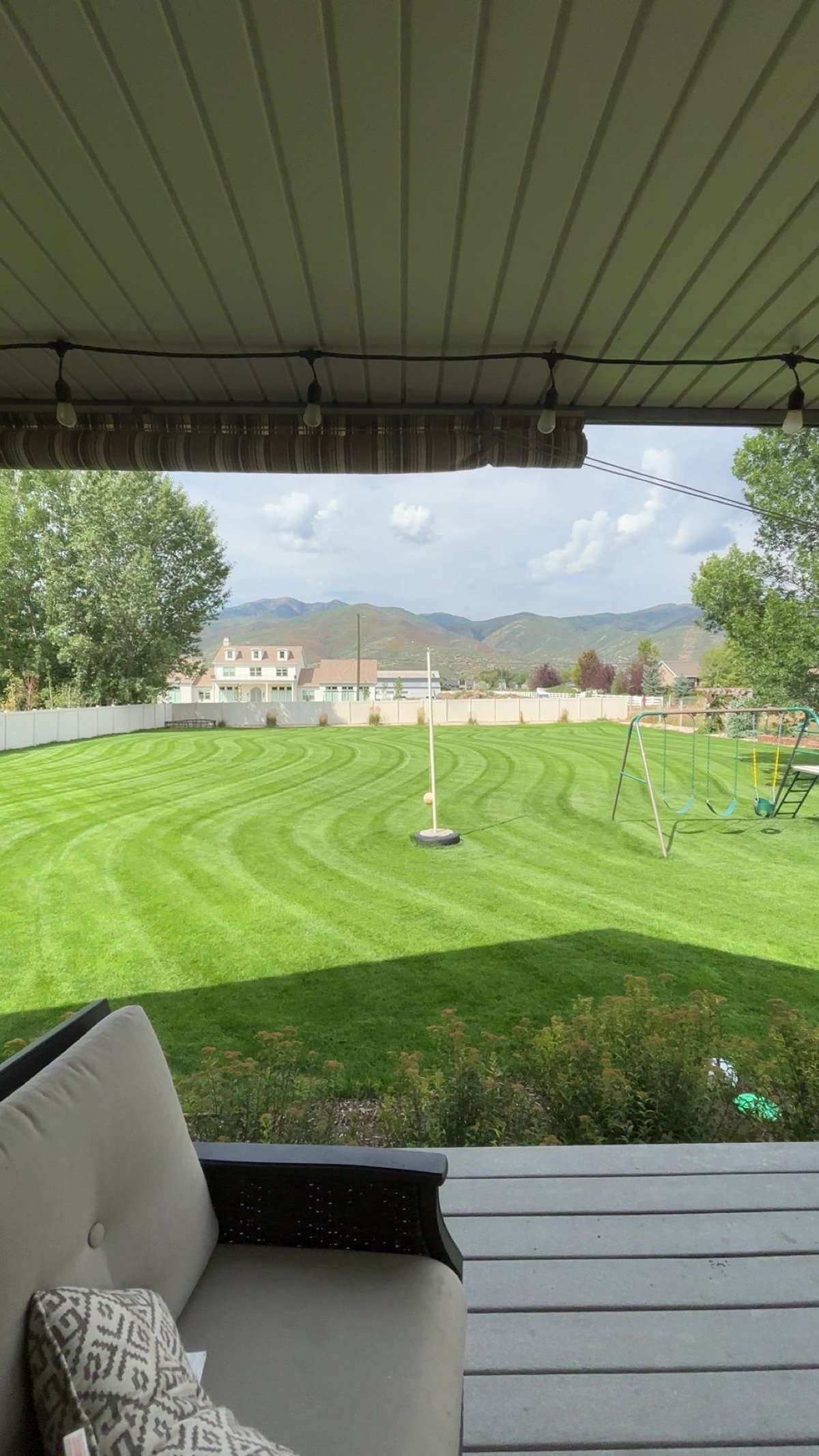 View from a covered patio overlooking a manicured soccer field with mountains in the background